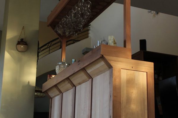 Bar jaguar, fabricado en madera de roble reciclado y madera de lenga. cuenta con 3 puertas y 3 cajones para almacenar en su parte posterior, ademas de un extenso colgador de copas. vista de general de la parte frontal