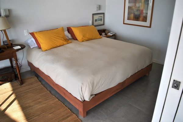 Cama Bufalo, fabricada en madera de raulí teñida con un tono chocolate suave. Vista general