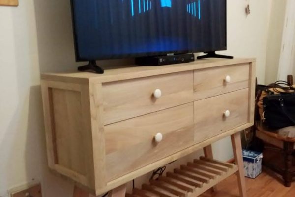 Cómoda Colibrí, fabricada en madera de castaño. vista general con televisor sobre la cómoda