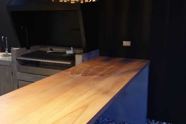 Mesón Rino, fabricado en Raulí vaporizado. Vista en quincho del cliente al lado de la parrila